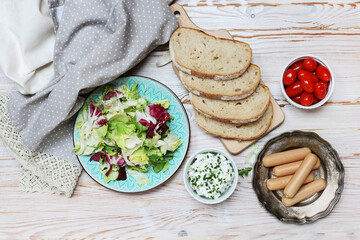 Sticker - Breakfast table with fresh salad, cottage, sliced bread and sausages.