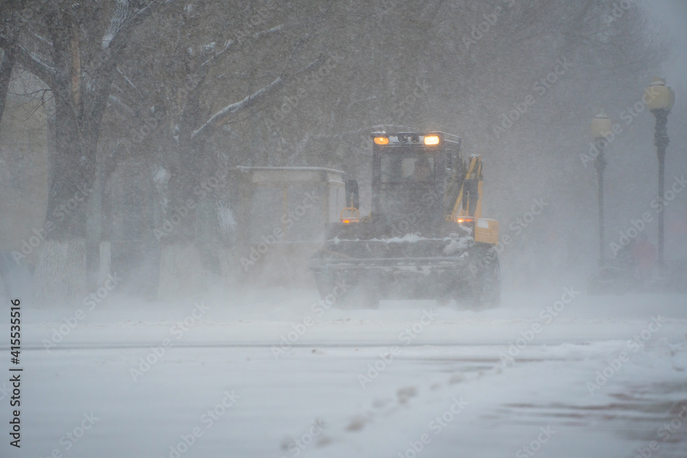 Snow removal equipment, utilities and municipal services are clearing the snow from the streets in the snow storm,Blizzard and snowstorm.Weather conditions in winter.Bad weather conditions with snow