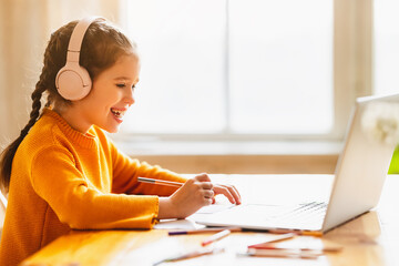 Canvas Print - Happy girl having online lesson via laptop at home