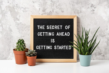 Wall Mural - The Secret Of Getting Ahead Is Getting Started. Motivational quote on letter board, cactus, succulent flower on white table. Concept inspirational quote of the day. Front view