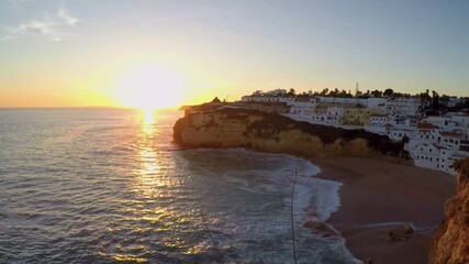 Sticker - Dreamy sunset on cliffed coastlines in Carvoeiro, Portugal. With lots of housing in the distance.