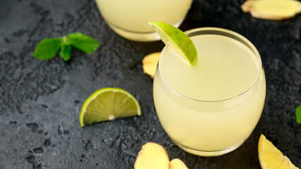 Wall Mural - Ginger and lemon beer sparkling fizzy drink in glasses with lime wedges on the side