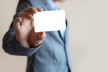 close up attractive business man holding blank white mock up card in hand.