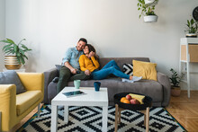 Embraced Couple Relaxing Together On Their Sofa At Living Room In Home.
Happy Couple Having Romantic Moment On Couch