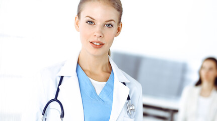 Woman - doctor standing in clinic. Physician at work, studio portrait. Medicine and health care concept