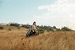 © Lord_Ghost - A woman sits on a motorcycle in a field
