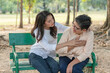 © Supachai - Senior Asian  woman suffering from chest pain with her daughter help and support while sitting relaxed on benches at the park