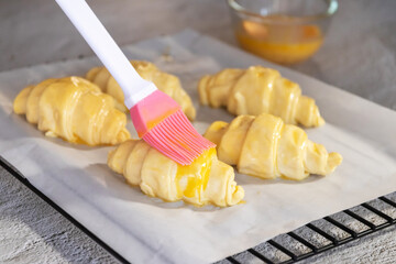 Wall Mural - Pastry chef baking croissants on white table with sunlight through from window.