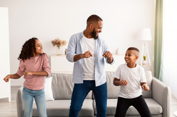 Wall Mural - African american father dancing to music with his little children