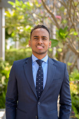 African businessman wearing suit and smiling outdoors vertical shot