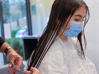 Canvas Print - Cute little girl in hairdressing salon wearing face mask during pandemic