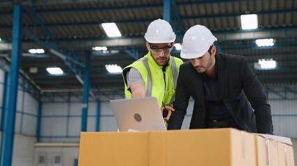 Two factory workers working and discussing manufacturing plan in the factory . Industry and engineering concept .