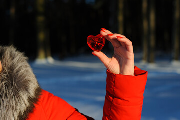 heart in hand. Red heart in a woman's hand, on a white background. girl holding a heart on a background of snow, winter forest, close-up. concepts of love, friendship, romance