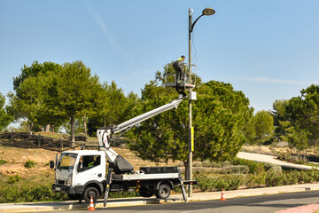 Paterna, Valencia, Spain: 02.18.2021; The  electricity employee changing the lamp in the streetlight