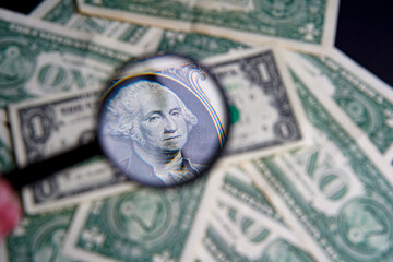 Wall Mural - US one dollar viewed through a magnifying glass, close up portrait of the late George Washington, first president of the United States. Bank image and commercial photo background.