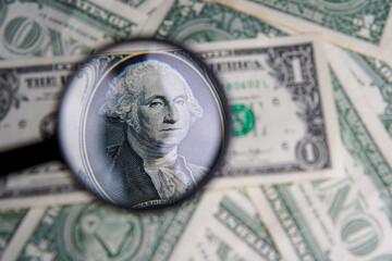 Wall Mural - US one dollar viewed through a magnifying glass, close up portrait of the late George Washington, first president of the United States. Bank image and commercial photo background.