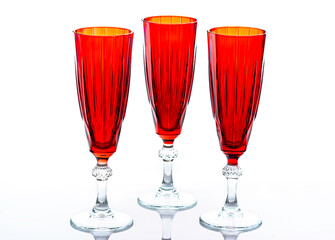 Three red glass champagne flutes on white background