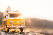 © stivog - Small hippie yellow van toy on the road. Vacation, traveling concept