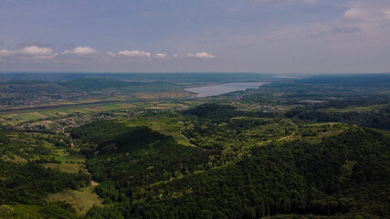 Wall Mural - Aerial shot of a wonderful landscape with green trees and a lake under the cloudy sky