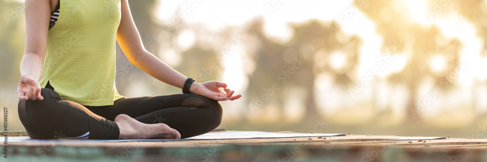Close up Woman practicing yoga doing yoga in morning park