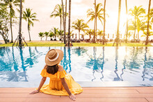 Young Woman Traveler Relaxing And Enjoying The Sunset By A Tropical Resort Pool While Traveling For Summer Vacation