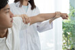 © Orathai - Female physiotherapists provide physical assistance to male patients with shoulder injuries massage their shoulders for muscle recovery in the rehabilitation center. Physiotherapy concepts