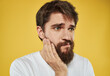 © SHOTPRIME STUDIO - man on a yellow background in a white t-shirt sad face beard model