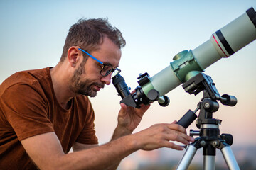 Wall Mural - amateur astronomer looking at the sky with a telescope.