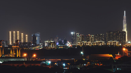 Aerial panoramic cityscape view of Ho Chi Minh city and the River Saigon, Vietnam with beautiful lights at night. Financial and business centers in developed Vietnam