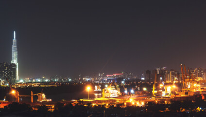 Aerial panoramic cityscape view of Ho Chi Minh city and the River Saigon, Vietnam with beautiful lights at night. Financial and business centers in developed Vietnam