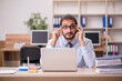 © Elnur - Young funny businessman employee working at workplace