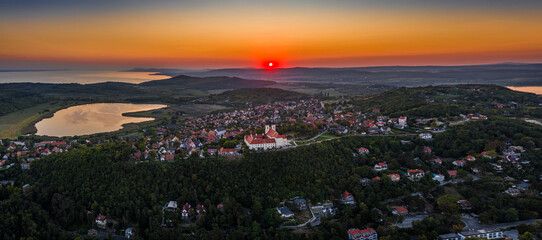 Wall Mural - Tihany, Hungary - Aerial panoramic view of Benedictine Monastery of Tihany (Tihany Abbey, Tihanyi Apatsag) with Inner Lake and beautiful golden sky at sunset over Lake Balaton on a summer afternoon