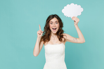 Wall Mural - Excited bride young woman 20s in white wedding dress hold empty blank Say cloud speech bubble holding finger up with new idea isolated on blue turquoise background. Ceremony celebration party concept.