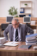 © Elnur - Old male employee unhappy with excessive work in the office