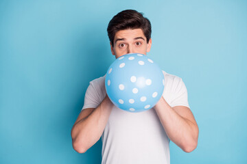 Sticker - Photo of optimistic man blow balloon wear white t-shirt isolated on teal color background