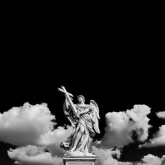 Wall Mural - Angel holding the Holy Cross with heavenly sky, A 17th century baroque masterpiece at the top of Sant'Angelo Bridge in the center of Rome (Black and White with copy space above)