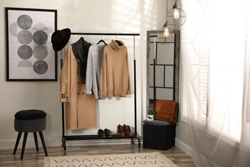 Wall Mural - Stylish warm clothes on rack in dressing room interior