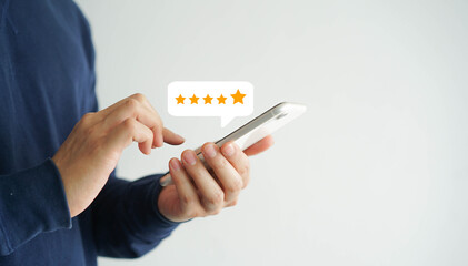 close up on customer man hand pressing on smartphone screen with gold five star rating feedback icon