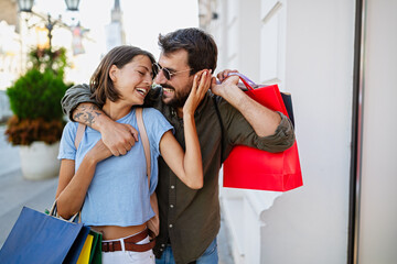 Young attractive happy couple with shopping bags outdoors