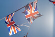 Great Britain British Flag pennants buntings isolated on blue background  for your text flag of great britain evolving in the wind Coronation of Charles III and Camilla