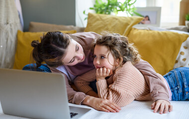 Wall Mural - Sisters indoors at home, using laptop. Lockdown concept.