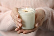 Woman holding burning candle with wooden wick, closeup