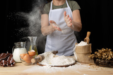 woman preparing bread dough on a wooden table in a bakery nearby, close up