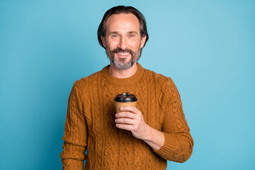 Poster - Photo of mature handsome positive cheerful good mood smiling man hold cup of coffee isolated on blue color background