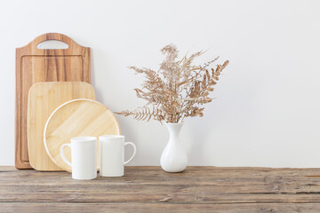 two cups and dried flowers on white kitchen