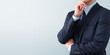© tadamichi - Thinking businessperson. In blue suit. Gray background with copy space.