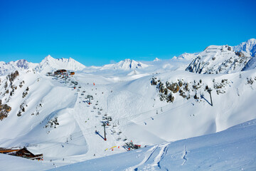 Panorama of French alps on the good sunny day, ski lift and station high in the mountain Les Arcs region