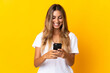 © luismolinero - Young hispanic woman over isolated yellow background sending a message or email with the mobile