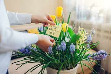 Happy Womens Day, 8 March gift. Woman found greeting card with blooming spring yellow blue flowers at home