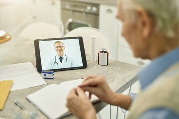 Wall Mural - Senior man having online session with medical doctor